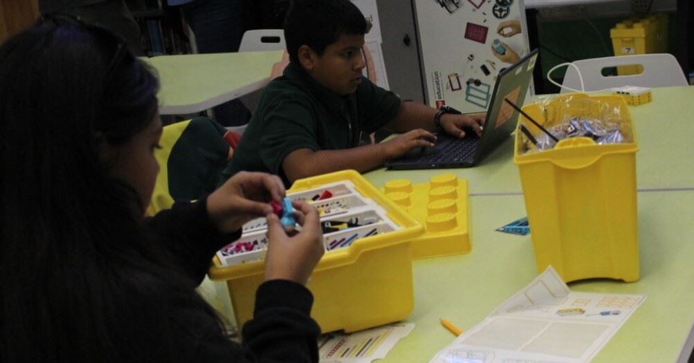  students using computers and spike legos